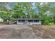 Charming one-story home featuring a carport and a covered porch, nestled in a serene, wooded setting at 8065 Highway 92 Dallas, Douglasville, GA 30134