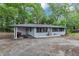 Quaint one-story home with a convenient carport and inviting front porch with cheerful red accents at 8065 Highway 92 Dallas, Douglasville, GA 30134