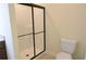 Bathroom features a walk in shower with black framed glass doors and a white toilet at 120 Chastain Nw Rd # 1104, Kennesaw, GA 30144
