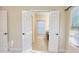 Bathroom entrance through bi-fold doors, featuring tiled floor and window at 120 Chastain Nw Rd # 1104, Kennesaw, GA 30144