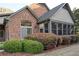 Rear exterior view showcases brick detail, well-maintained landscaping, and a cozy screened-in porch at 120 Chastain Nw Rd # 1104, Kennesaw, GA 30144
