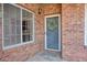 Inviting front entrance with brick facade, decorative wreath, and a welcoming doormat on the porch at 120 Chastain Nw Rd # 1104, Kennesaw, GA 30144