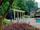 Inviting community pool area with lounge chairs, manicured landscaping, and shaded pergola at 120 Chastain Nw Rd # 1104, Kennesaw, GA 30144