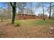 Photo of the brick house's backyard which has lots of overgrown grass and a rusty trashcan at 5273 Crystal Ln, Atlanta, GA 30349