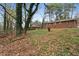 Brick house backyard with plenty of trees and overgrowth, including a rusty barrel in the yard at 5273 Crystal Ln, Atlanta, GA 30349