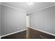 Picture of the bedroom which features dark hardwood floors and light-grey, wood-paneled walls at 5273 Crystal Ln, Atlanta, GA 30349