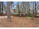 Exterior of a brick home with bare landscaping and surrounded by mature trees at 5273 Crystal Ln, Atlanta, GA 30349