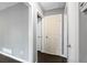 Hallway with dark hardwood floors and light-grey walls with white trim, featuring several paneled doors at 5273 Crystal Ln, Atlanta, GA 30349