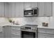 Well-appointed kitchen with stainless appliances, modern gray cabinets, and stylish herringbone backsplash at 112 Rosaire Nw Pl, Atlanta, GA 30327