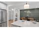 Open-concept kitchen with island, stainless steel refrigerator, and view into adjacent dining room with wainscoting at 112 Rosaire Nw Pl, Atlanta, GA 30327