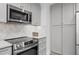Modern kitchen features stainless steel appliances, gray cabinets, and stylish herringbone backsplash at 112 Rosaire Nw Pl, Atlanta, GA 30327