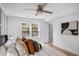 Comfortable bedroom features a ceiling fan, wood floors, paneling, and a view to the outside at 112 Rosaire Nw Pl, Atlanta, GA 30327