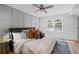 Comfortable bedroom features a ceiling fan, wood floors, paneling, and a view to the outside at 112 Rosaire Nw Pl, Atlanta, GA 30327