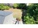 Aerial view of the property featuring a well maintained backyard, trees, driveway and a glimpse of the home's roof at 1472 Hartman Sw Dr, Lilburn, GA 30047