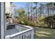 Exterior view of backyard with wooden deck, mature trees, and green lawn at 1472 Hartman Sw Dr, Lilburn, GA 30047