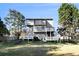 View of the back of the house from the yard, featuring a deck, patio, and multiple windows at 1472 Hartman Sw Dr, Lilburn, GA 30047