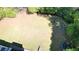 Aerial view of the spacious backyard surrounded by lush greenery, including a firepit and trampoline at 1472 Hartman Sw Dr, Lilburn, GA 30047