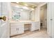 Bright bathroom featuring double sinks, white cabinets and a large mirror at 1472 Hartman Sw Dr, Lilburn, GA 30047