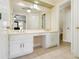 Large bathroom with dual sinks, white cabinets, and a large mirror at 1472 Hartman Sw Dr, Lilburn, GA 30047
