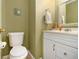 Cozy half bathroom featuring a toilet and a white sink vanity with gold fixtures at 1472 Hartman Sw Dr, Lilburn, GA 30047