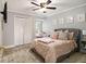 Comfortable bedroom with a gray upholstered bed, carpet floors, ceiling fan, and natural light at 1472 Hartman Sw Dr, Lilburn, GA 30047