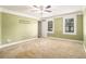 Spacious bedroom featuring neutral carpet, crown molding, and two bright windows at 1472 Hartman Sw Dr, Lilburn, GA 30047
