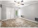 Bedroom with neutral carpet, ceiling fan, and built in closet with a window view at 1472 Hartman Sw Dr, Lilburn, GA 30047