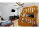 Bright bedroom with a wooden bunk bed, TV, desk, neutral walls, and a ceiling fan at 1472 Hartman Sw Dr, Lilburn, GA 30047