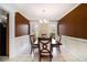 Elegant dining room with stylish chandelier and rich brown walls at 1472 Hartman Sw Dr, Lilburn, GA 30047