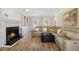 Bright living room featuring a cozy fireplace, modern furniture, and hardwood floors at 1472 Hartman Sw Dr, Lilburn, GA 30047