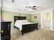 A spacious bedroom with a dark bed frame and carpet flooring at 1472 Hartman Sw Dr, Lilburn, GA 30047