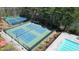 Aerial shot capturing multiple tennis courts with surrounding trees and community swimming pool at 1472 Hartman Sw Dr, Lilburn, GA 30047