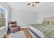 This bedroom features a neutral palette with hardwood floors, a bed, and a cushioned leather chair at 3670 Cedar Springs Ln, Loganville, GA 30052