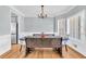 Bright dining room with wainscoting, chandelier, large windows and modern furniture at 3670 Cedar Springs Ln, Loganville, GA 30052