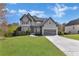 Charming two-story home with gray exterior, well-manicured lawn, and attached garage at 3670 Cedar Springs Ln, Loganville, GA 30052