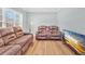 Cozy living room with hardwood floors, large window, reclining sofa, and a modern entertainment center at 3670 Cedar Springs Ln, Loganville, GA 30052