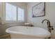 Freestanding soaking tub in a bright bathroom with plantation shutters and modern fixtures at 4732 Corina Ne Pl, Roswell, GA 30075