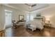 Bright bedroom featuring hardwood floors, tray ceilings, and a cozy seating area at 4732 Corina Ne Pl, Roswell, GA 30075