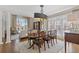 Bright dining room with decorative light fixture, large windows, and a view into the living room at 4732 Corina Ne Pl, Roswell, GA 30075