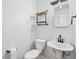 Bright bathroom features pedestal sink, modern fixtures, and decorative shelves at 4974 Meadow Ln, Marietta, GA 30068