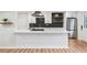 Island kitchen boasts stainless appliances, white cabinetry and hardwood floors at 4974 Meadow Ln, Marietta, GA 30068