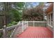 Back deck with a red floor and white railing, as well as a bush in the background at 6227 Braidwood Nw Way, Acworth, GA 30101