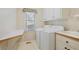 Bright laundry room with washer, dryer, and folding table by window at 6227 Braidwood Nw Way, Acworth, GA 30101
