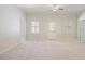 Bright living room featuring neutral walls, carpet, ceiling fan, and ample natural light from multiple windows at 6227 Braidwood Nw Way, Acworth, GA 30101