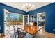 Dining room with blue walls and hardwood floors opens to the outdoor deck for an open-air experience at 1087 High Point Ne Dr, Atlanta, GA 30306