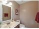 Cozy powder room featuring a vanity with a sink, a toilet, and neutral decor with a large mirror at 165 Carriage Gate Dr, Sharpsburg, GA 30277
