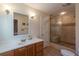 Bathroom showcasing a walk-in shower with decorative tile, a neutral color palette, and a vanity at 165 Carriage Gate Dr, Sharpsburg, GA 30277