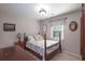 Bedroom featuring a four-poster bed, neutral walls, and a window with natural light at 165 Carriage Gate Dr, Sharpsburg, GA 30277