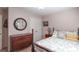 Charming bedroom featuring a wooden dresser, and a queen-sized bed with decorative pillows at 165 Carriage Gate Dr, Sharpsburg, GA 30277