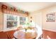 Sunny breakfast nook with warm accents, wood table, and a large window with a view of mature trees at 165 Carriage Gate Dr, Sharpsburg, GA 30277